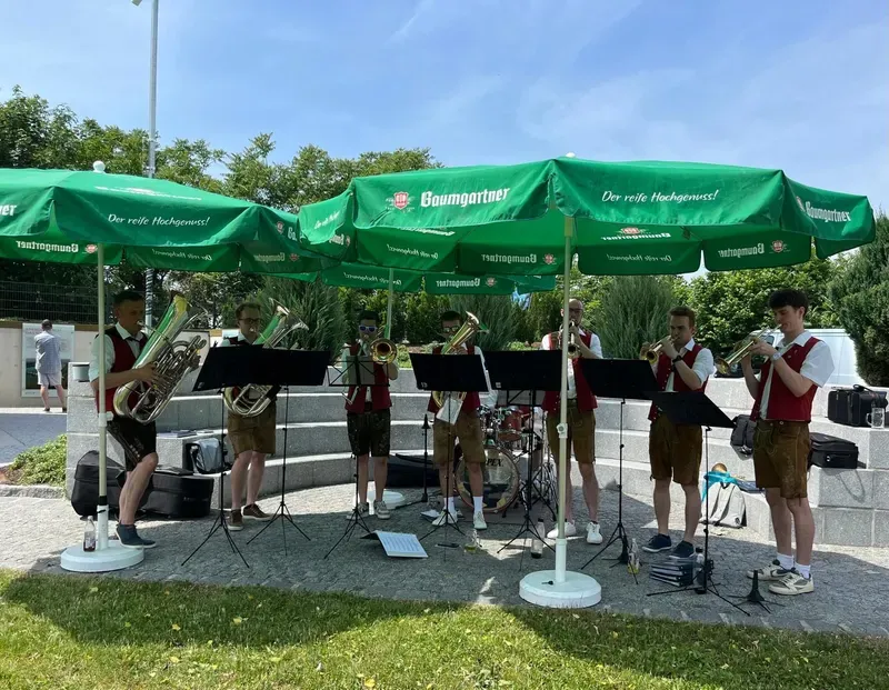 Die WindBradler beim Open-Air-Auftritt unter Sonnenschirmen