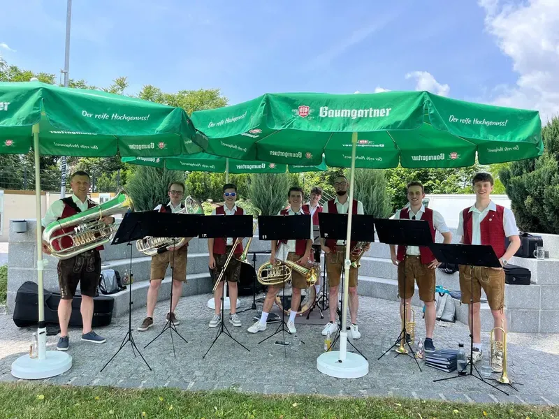 Die WindBradler aus Altschwendt beim Auftritt unter Sonnenschirmen